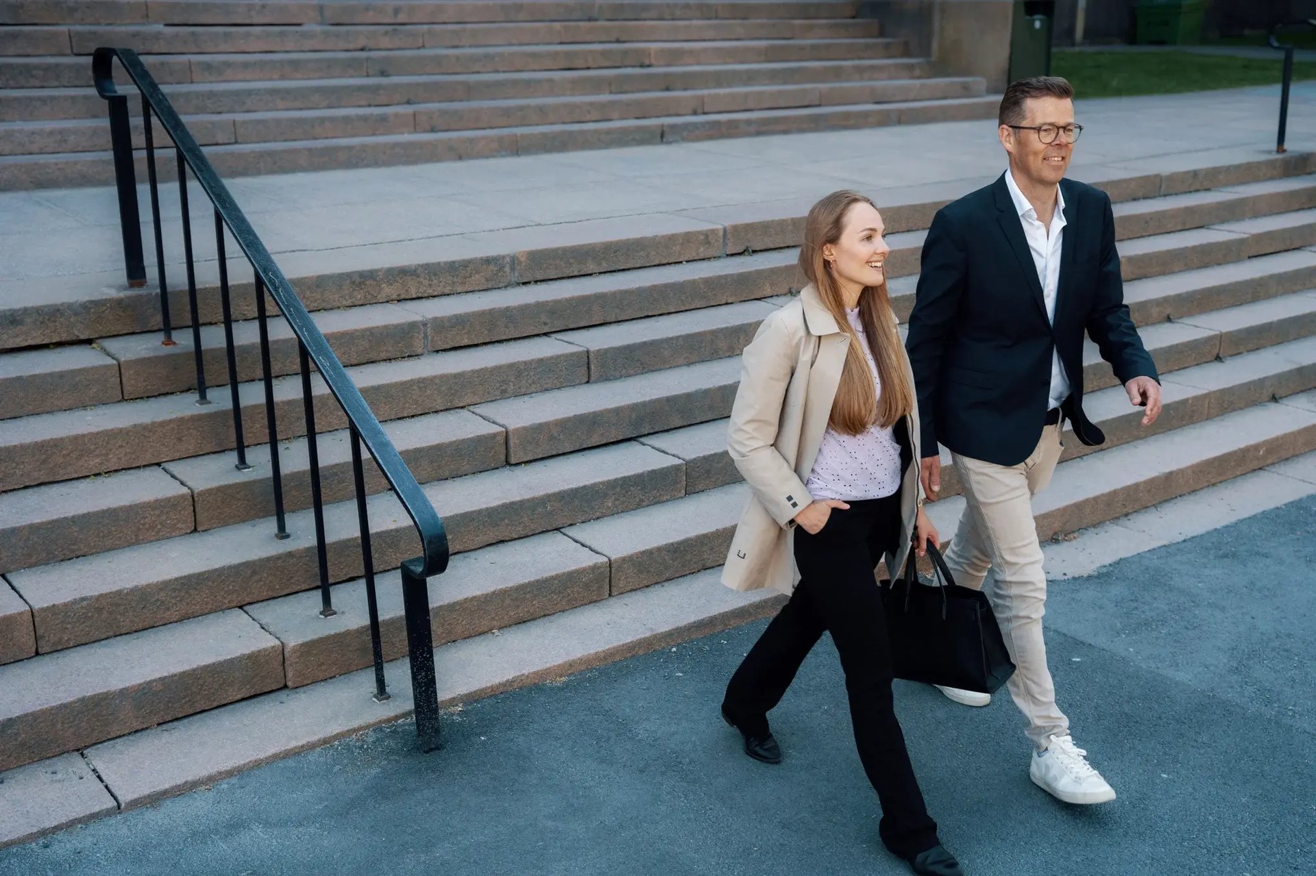 Profesjonell mann og kvinne går ned trapp